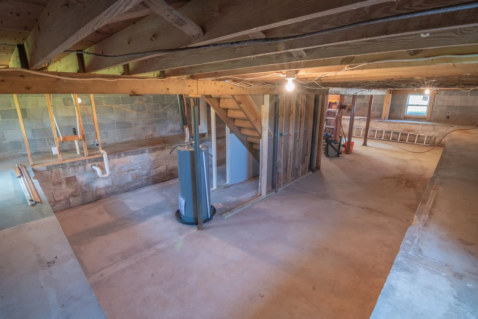 Basement with exposed plumbing pipes near a sump pit