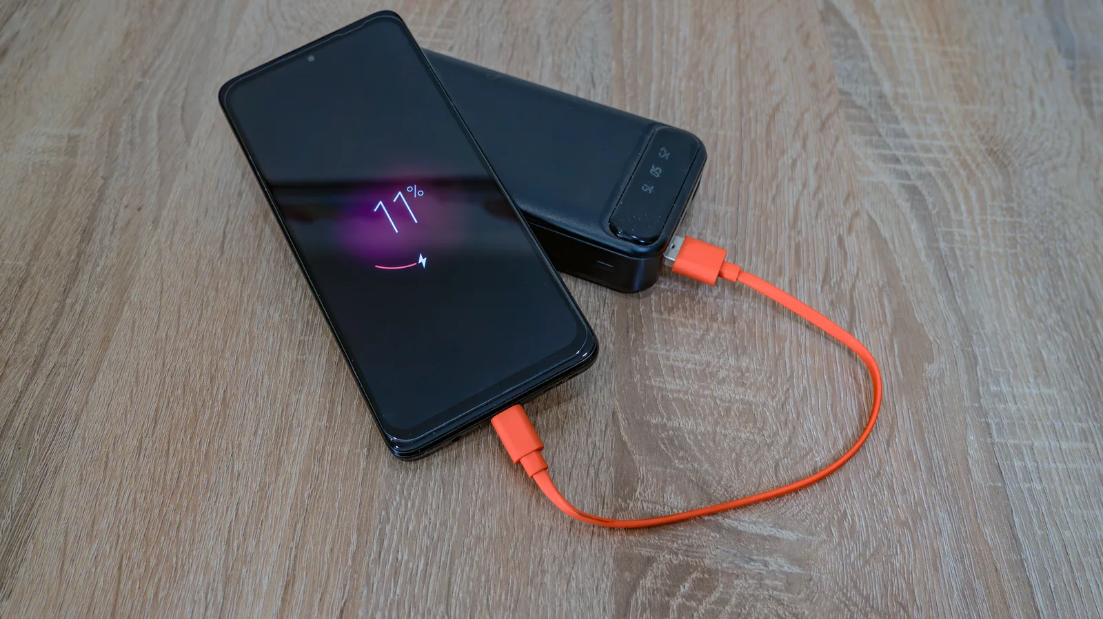 Phone at 11 percent charging from a power bank during a power outage