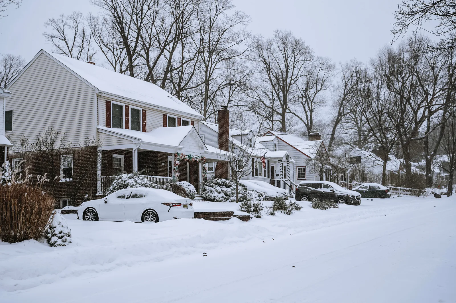 Snowy suburban street with houses during winter