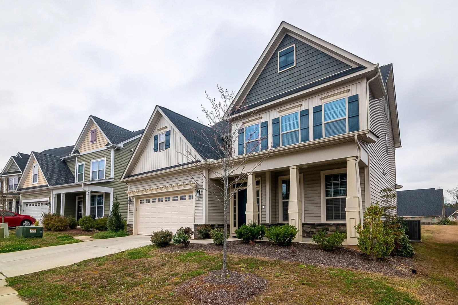 Row of suburban American homes with driveways and landscaped lawns