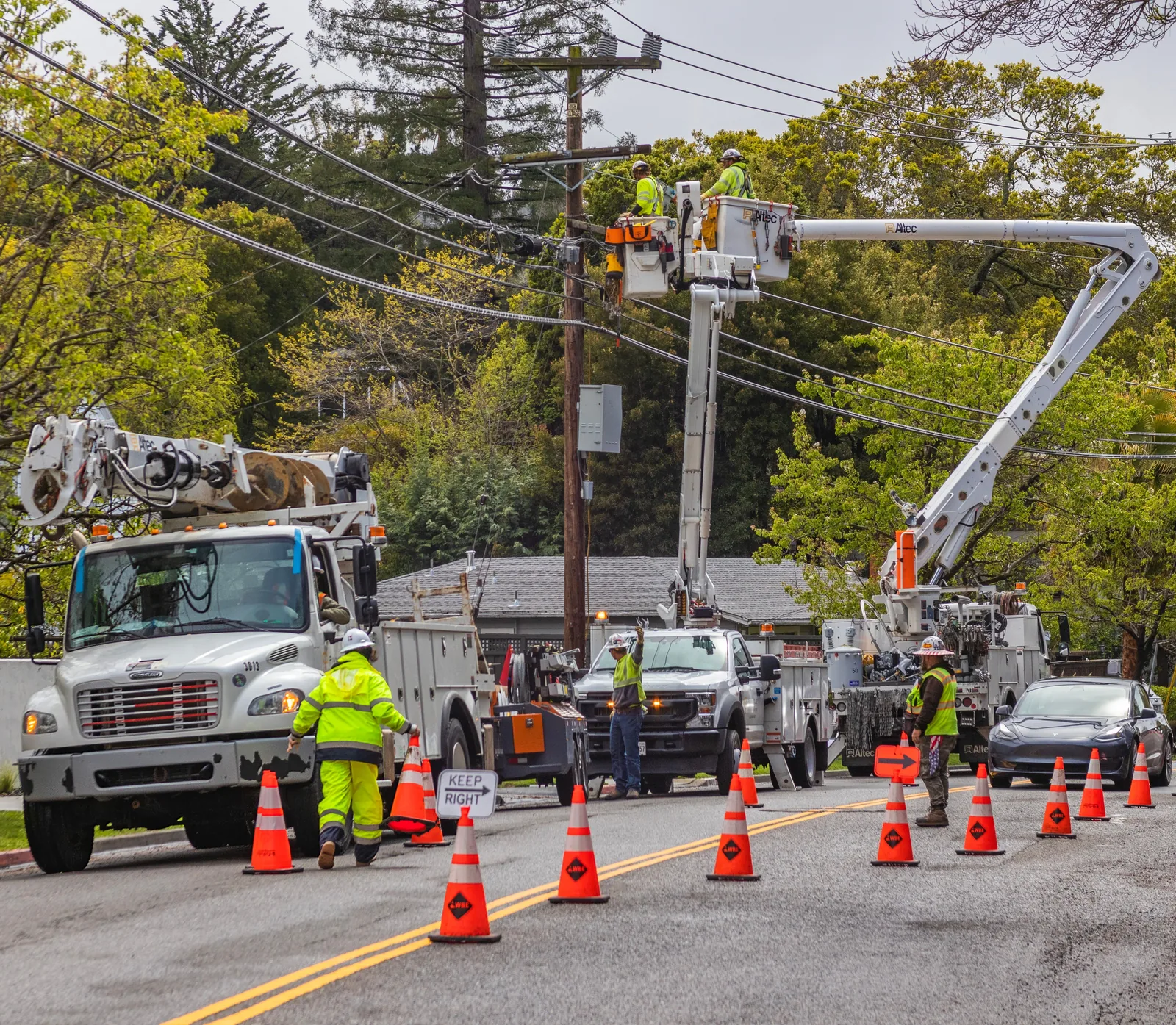 Utility crew repairing power lines on a suburban street